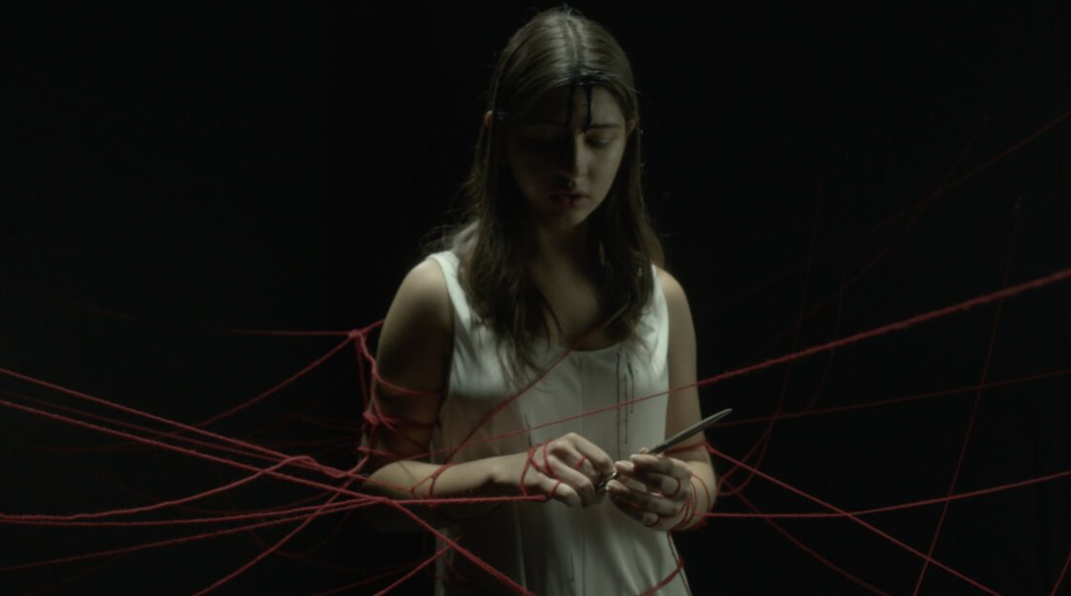 Woman in white dress and gold earrings walking down runway